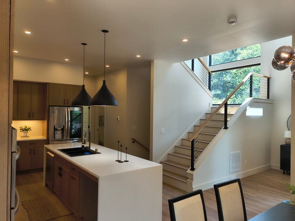 Modern kitchen with island and staircase in Asheville custom home