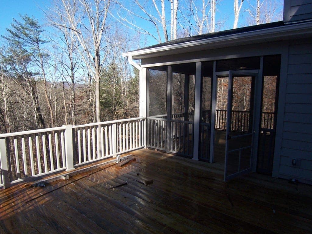 Deck and screened porch addition surrounded by trees
