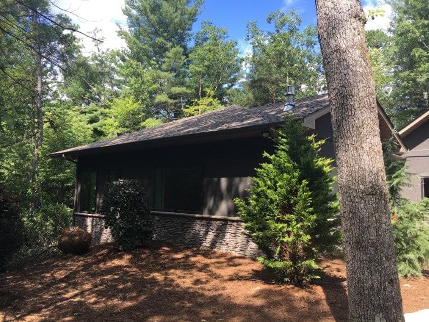 Custom home with stone accents nestled in trees